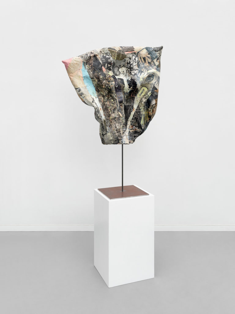 <em>Black Axial</em> front, 2021, medical foam and plastic, acrylic paint, found paper and leather with iron stand, 45x28x4"
